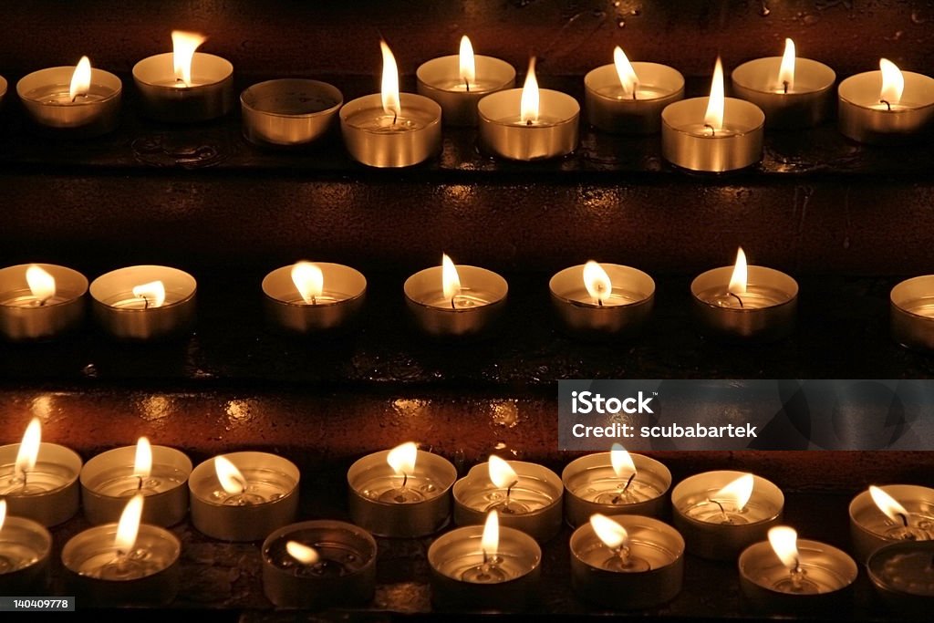 Memorial candles Prayer candles aka offering, votive or memorial candles lit in a dark church Candle Stock Photo