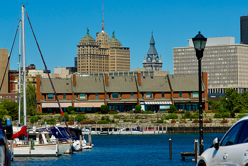 Buffalo, New York, USA - June 18, 2022: Downtown Buffalo’s cityscape rises behind a residential building adjacent to the Erie Basin Marina near the Niagara River.