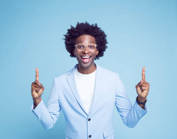 istock Cheerful man pointing against blue background 1404098651