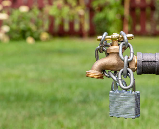 Outdoor water faucet with lock and chain. Water restriction, supply and shortage concept stock photo