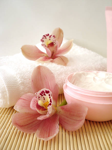istock container of cosmetic moisturizing cream with pink orchids and towel 140410311