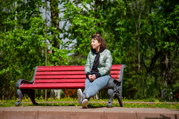 istock Young woman sitting on a bench 1404105034