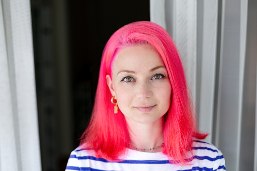 Beautiful happy girl with pink hair in striped t-shirt