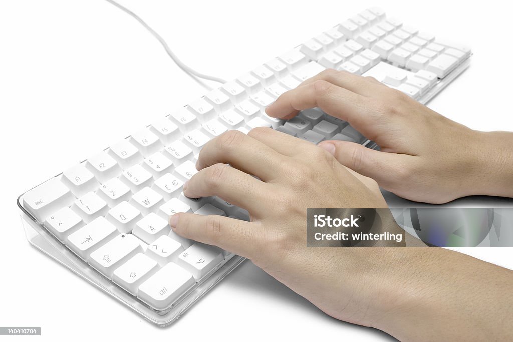 Writing on a White Computer Keyboard Female hands writing on a white  computer keyboard. White background. Accessibility Stock Photo