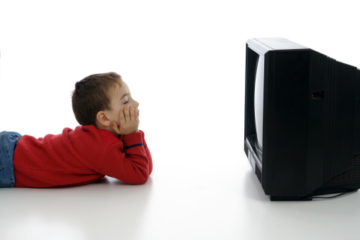 little boy lying in front of the tv and staring at it - against white background