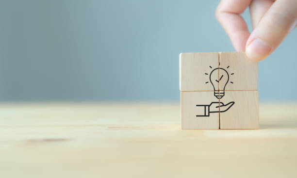 istock New idea, solution, suggestion concept.  Hand puts the wooden cubes with light bulb on hand icon on beuatiful grey background and copy space. Business review, strategy suggestion for business growth. 1404118953