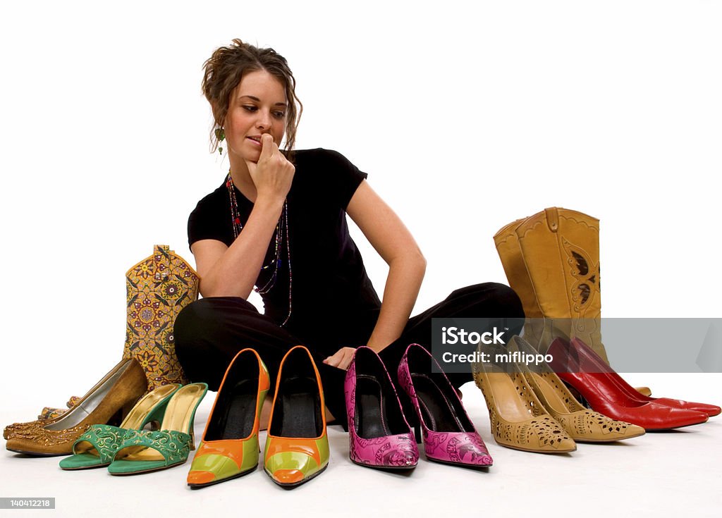 A woman deciding which pair of colorful shoes to wear Young pretty lady trys to decide what shoes to wear, decisions Choice Stock Photo