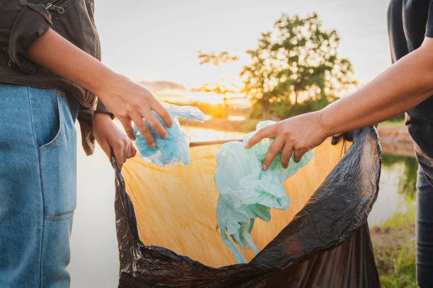 istock woman hand picking up garbage plastic bag for cleaning at park 1404122271