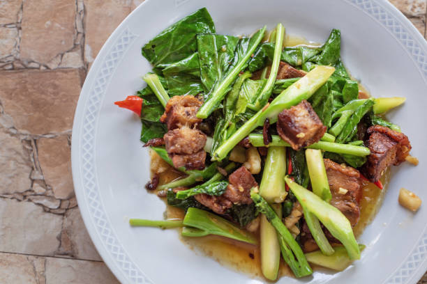 istock Stir fried kale vegetables with fried pork in the plate for breakfast or lunch or dinner,some menu on food table 1404126224