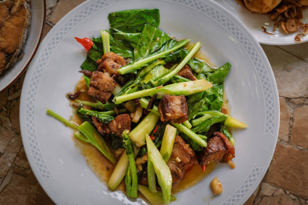 istock Stir fried kale vegetables with fried pork in the plate for breakfast or lunch or dinner,some menu on food table 1404126304