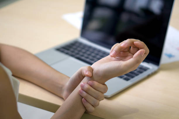 istock Young woman injured her wrist from using laptop computer for a long time. Closeup 1404127195