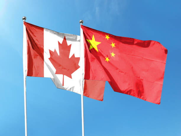 istock Canada and China flags with blue sky. waving blue sky 1404129398