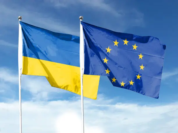 Photo of Ukraine and EU flags with blue sky. waving blue sky