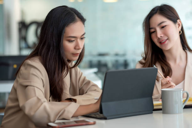 istock Two young Asian businesswoman is happy working on presentations using papers and tablet placed at the office. 1404136819