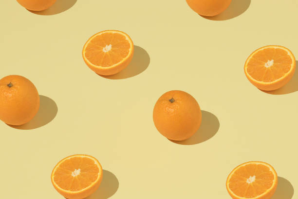 istock Trendy pattern with fresh orange on a yellow background. Minimal summer wallpaper. 1404139416