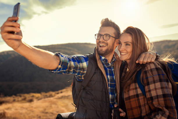 istock Couple with backpacks making selfie while they hiking on the mountain. 1404140944