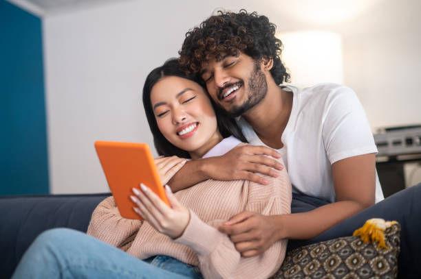 istock Young cute couple having a video call and looking involved 1404142061
