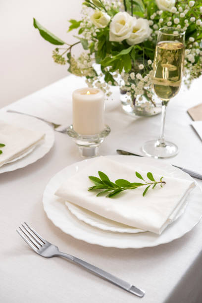 istock Wedding teble decoration with white flowers, glasses and white napkins. Elegantly decorated table at a wedding reception. Festive table setting. The wedding decor. 1404145209