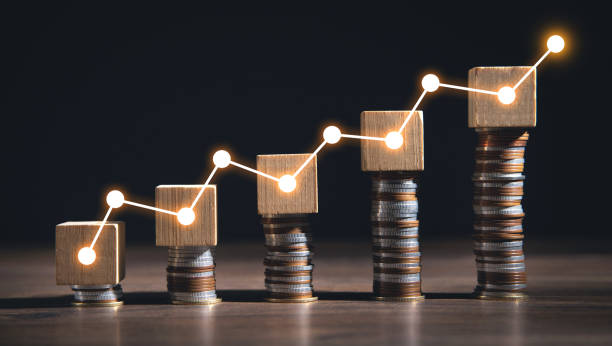 istock Coins with a growth graphs on wooden cube. Business 1404149207