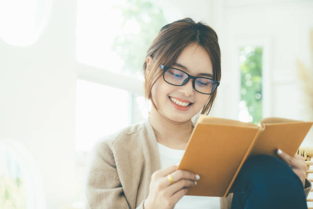 istock Young collage student reading a book sitting in a chair. 1404149603