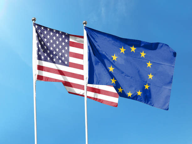istock USA and EU flags with blue sky. waving blue sky 1404149616