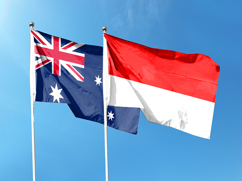 Australia and Indonesia flags with blue sky. waving blue sky