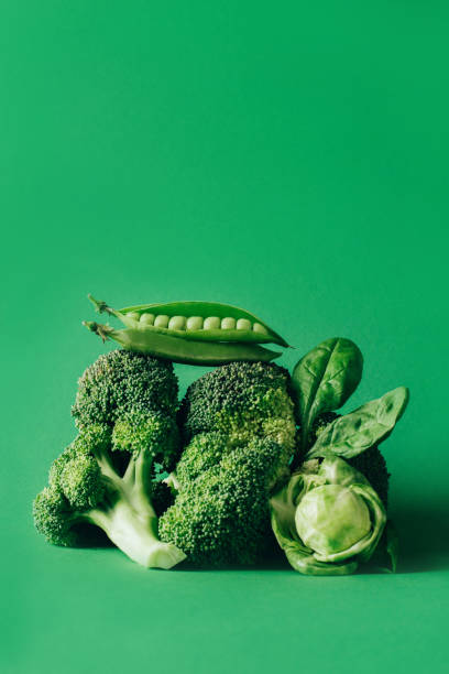 pyramidenbilanz von grünem gemüse auf grünem grund - leaf vegetable broccoli spinach vegetable stock-fotos und bilder