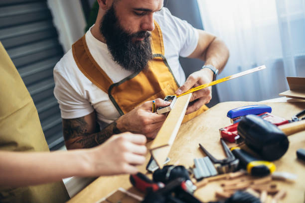 istock Father teaches his son to plan wood in a carpentry workshop. Hobby and education concept 1404150793