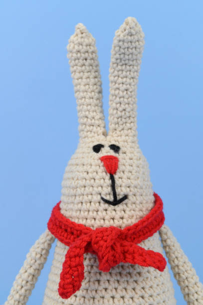 istock Gray knitted Easter Bunny in a red scarf 1404151738