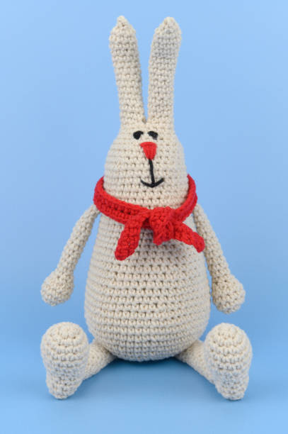 istock Gray knitted Easter Bunny in a red scarf 1404152058