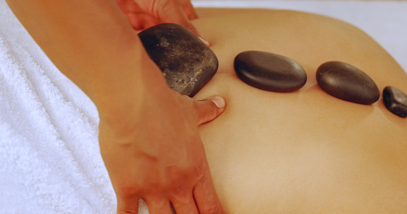 Woman having a hot stone massage at a spa. Closeup of woman having a relaxing day of beauty and wellness at a luxury health spa with lastone therapy