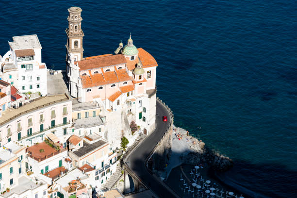 View from above, stunning aerial view of a beautiful old church with a slender bell tower situated on a cliff just beside the coast line. Atrani, Amalfi Coast, Salerno, Italy. View from above, stunning aerial view of a beautiful old church with a slender bell tower situated on a cliff just beside the coast line. Atrani, Amalfi Coast, Salerno, Italy. praiano photos stock pictures, royalty-free photos & images