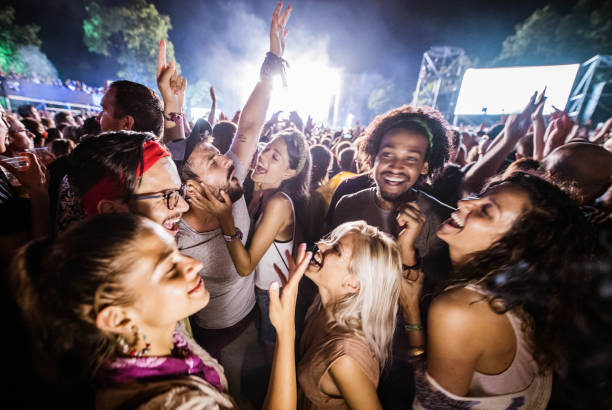 amigos alegres bailando y firmando en festival de música por la noche. - concierto de música pop fotografías e imágenes de stock