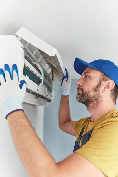 istock Repairman cleaning and fixing indoors AC unit. 1404156810