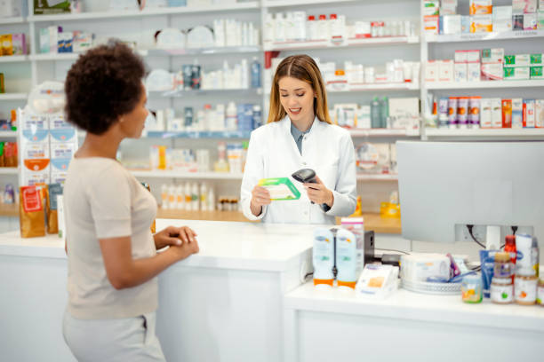 Pharmacist Scanning Medicine's Barcode Pharmacy Drugstore: Female Pharmacist Scanning Medicine's Barcode in a Pharmacy healthcare and medicine business hospital variation stock pictures, royalty-free photos & images