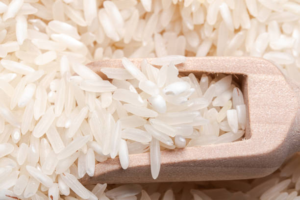 istock Raw rice in a wooden spoon. Thai jasmine rice. 1404158170