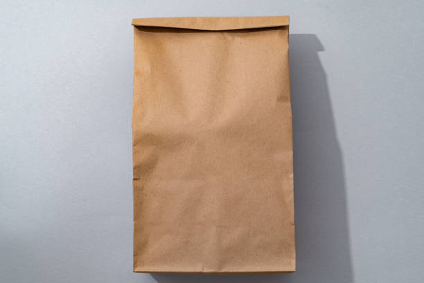 istock Craft paper bag on gray background flat lay top view 1404158563