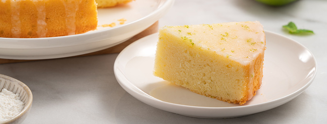 Delicious Lemon Glazed Pound Sponge cake in a plate on white marble table background.