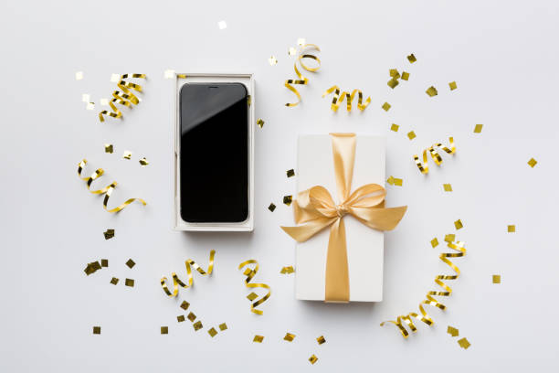 istock Opened gift box with gold ribbon and smartphone on color background, top view. Blank open box packaging mockup , Template for your design - branding mockup 1404159813