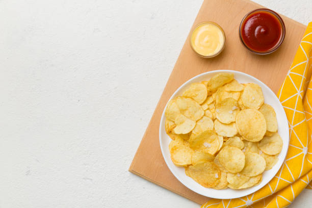 istock Top view chips with sause in bowl on colored background, top view with copy space 1404159815