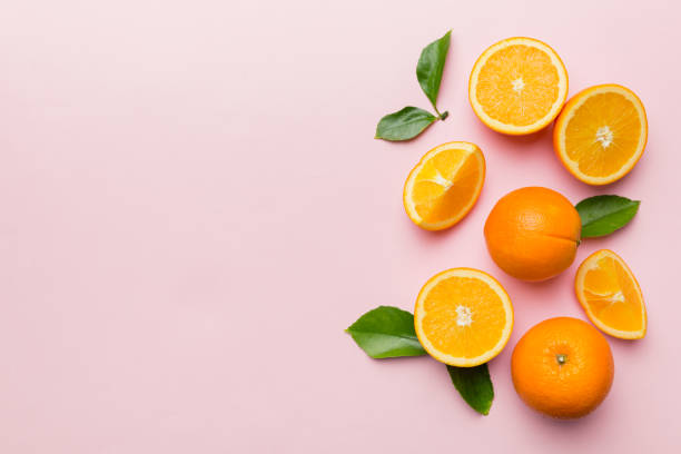 istock fresh Fruit orange slices on colored background. Top view. Copy Space. creative summer concept. Half of citrus in minimal flat lay with copy space 1404159844