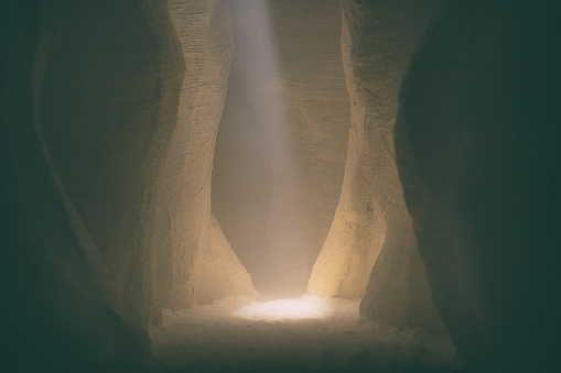 A thin beam of sunlight illuminates a mysterious slot canyon. Miniature photography.