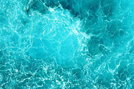 Defocus blurred water in swimming pool rippled water detail background