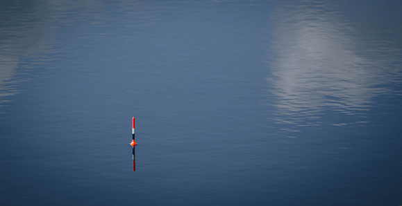 Float for fishing on calm water with space for text, fish bite alarm, rest and tranquility