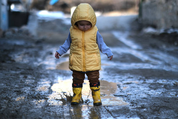 istock Little boy playing in mud water 1404164700