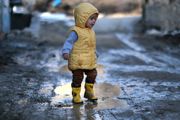 istock Little boy playing in mud water 1404164703