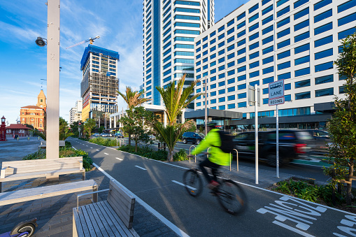 The shot of cyclist riding cycle in modern city on bicycle on road in front of buildings.
