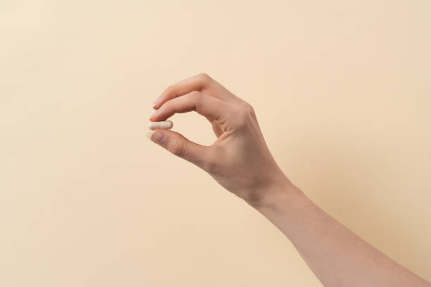 istock a female hand holding a single pill 1404167193