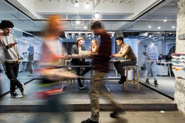 Young creative people working in the office among people in blurred motion. stock photo