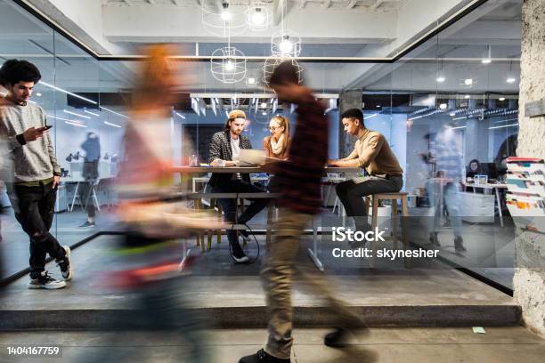 Young Creative People Working In The Office Among People In Blurred Motion Stock Photo - Download Image Now